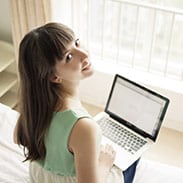 Happy woman looking away from her laptop