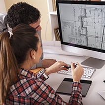 Man and woman looking at plans on an iMac